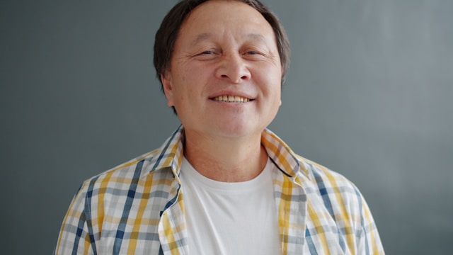 Smiling man in plaid shirt representing relief from anxiety through acceptance