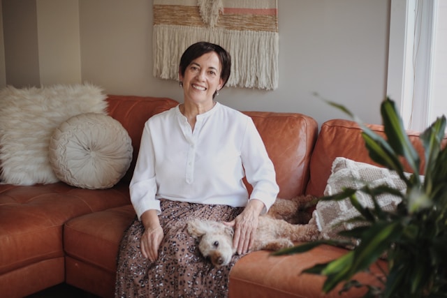 Smiling woman relaxing at home with dog after successful anxiety treatment in Illinois