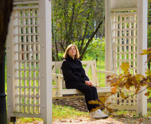 Woman sitting peacefully on porch swing practicing acceptance and mindfulness for anxiety management
