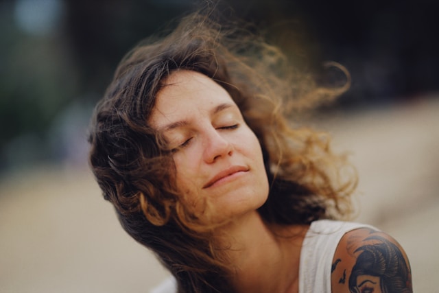 Woman with eyes closed in peaceful moment practicing mindful breathing for anxiety management