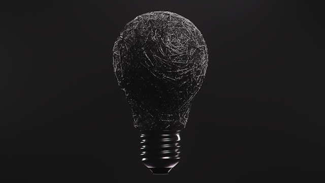 Light bulb with tangled chaotic wire inside on black background