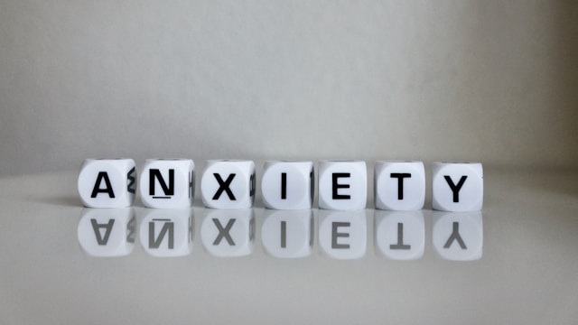 Word anxiety spelled with letter blocks on a reflective surface